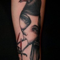 Mystical painted colored creepy tattoo bird with woman portrait on arm