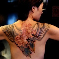 Natürlich detaillierte farbige Blumen Tattoo am oberen Rücken mit Vogelflügeln