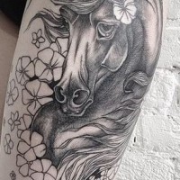 Natural looking big colored sad horse tattoo on thigh stylized with beautiful flowers