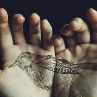 Natural looking black ink detailed divided bird tattoo on hands