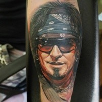 Natural looking colored arm tattoo of cool looking rock player