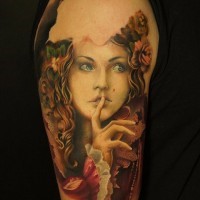 Tatuaje en el brazo,  mujer divina con flores en el pelo en el traje antiguo