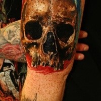 Natural looking colored biceps tattoo of human skull part