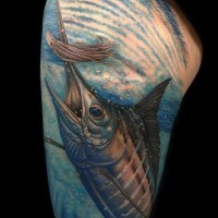 Tatuaje en el brazo, pez bien pintada en el agua azul clara