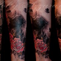 Natürlich aussehendes farbiges Unterarm Tattoo der niedlichen Katze mit Blumen und Schmetterlingen
