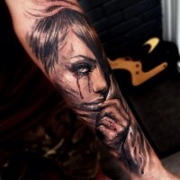 Natural looking colored forearm tattoo of crying woman with cross