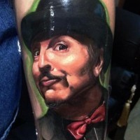 Natural looking colored funny man portrait tattoo on forearm