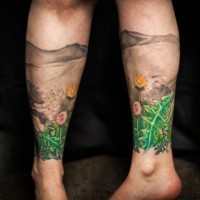 Tatuaje en la pierna,
 paisaje hermoso con montañas y flores