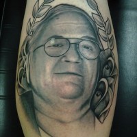 Tatuaje en la pierna, retrato de hombre en gafas con hojas y flores