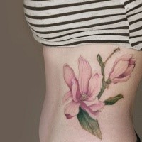 Natural looking colored pink flowers tattoo on side