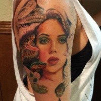 Natural looking colored shoulder tattoo of woman face with snakes