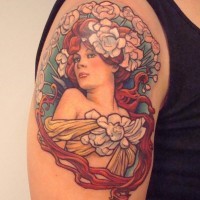 Natural looking colored small shoulder tattoo of woman portrait with flowers