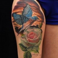 Natural looking colored thigh tattoo of beautiful bird with flowers