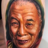 Natural looking colored thigh tattoo of old Asian man portrait