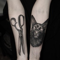 Natural looking demonic cat tattoo combined with scissors on forearms
