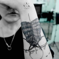 Natural looking detailed black ink insect tattoo on arm