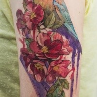 Natural looking shoulder tattoo of bird with flowers