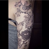 Tatuaje en el brazo, aves divinas con nido en la rama