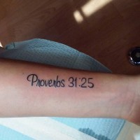 Neat dark black ink lettering proverbs 31:25 forearm length tattoo