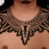 Tatuaje en el pecho, 
collar negro, estilo azteca