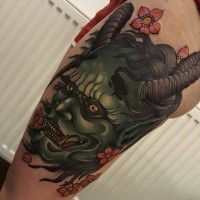 Neo japanese style colored thigh tattoo of demonic face with flowers