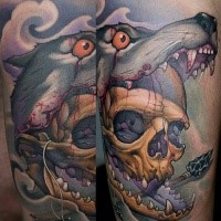Neo traditional style colored arm tattoo of human skull in bloody wolf mouth