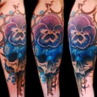 neo traditional style colored arm tattoo of human skull with big flower
