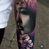 Neo traditional style colored forearm tattoo of Asian geisha with flowers