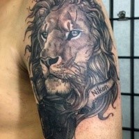 New school style black and white lion with camera and lettering tattoo on upper arm