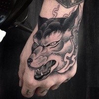 New school style colored hand tattoo of demonic wolf head with flames