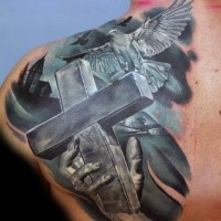 New school style dark colored back and shoulder tattoo of big cross with human hand and flying pigeon