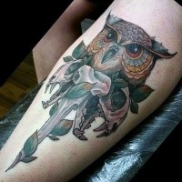New school style owl's head with animal skulls and green leaves colored thigh tattoo