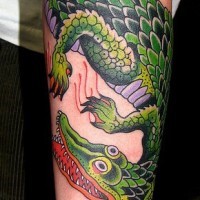 Nettes cartoonisches farbiges großes detailliertes Alligator Tattoo am Arm