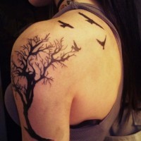 Tatuaje en el hombro, cuervos vuelan sobre el árbol