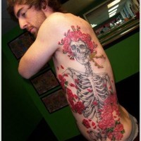 particolare disegno colorato massiccio donna scheletro con fiori tatuaggio su lato di corpo