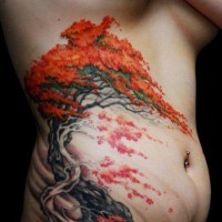 Tatuaggio colorato sul fianco l'albero con le foglie arance