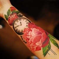 Nice looking colored forearm tattoo of big flower with clock