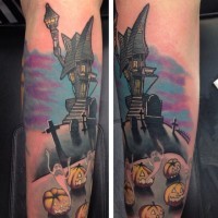 Nice looking colored old creepy house tattoo on forearm with cemetery