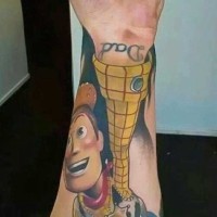 Nice looking colored Toy Story cowboy hero tattoo on forearm with lettering
