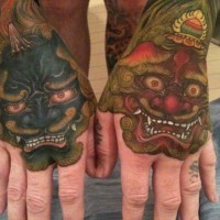 Nice looking multicolored on hands tattoo of various Asian demons