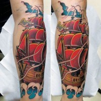 Tatuaje en el antebrazo,
barco hermoso con velas rojas, estilo old school
