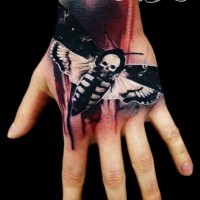 Nice real photo like 3D night butterfly tattoo on hand stylized with white skull