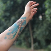 Tatuaje en el antebrazo, chica joven a dragón  fantástico, estilo de dibujos asiáticos
