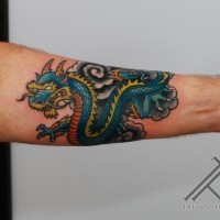 Old cartoon like Asian little dragon tattoo on arm