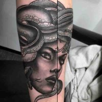 Old cartoon style painted black ink Medusa head tattoo on arm