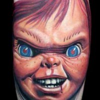 Old horror cartoon like colored evil bloody doll tattoo on arm