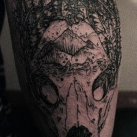 Old looking black ink tattoo of animal skull with bird