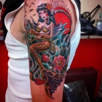 Old school beautiful looking colored mermaid with anchor tattoo on shoulder stylized with flowers and sun
