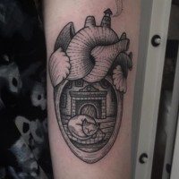 Old school black ink heart shaped tattoo on arm stylized with sleeping cat