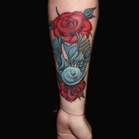 Tattoo von blauem Vogel mit Rose in altschulischem Stil am Unterarm